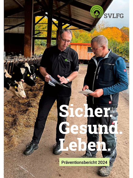 Vergrößerung des Bildes für Zwei Personen stehen vor einem Rinderstall. Eine Person trägt ein Shirt mit dem SVLFG-Logo und zeigt der anderen Person in einem Flyer auf eine Textstelle..