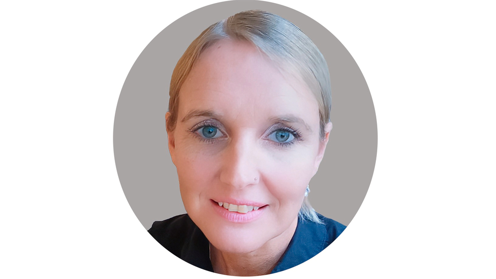 Vergrößerung des Bildes für Eine Frau schaut freundlich in die Kamera.