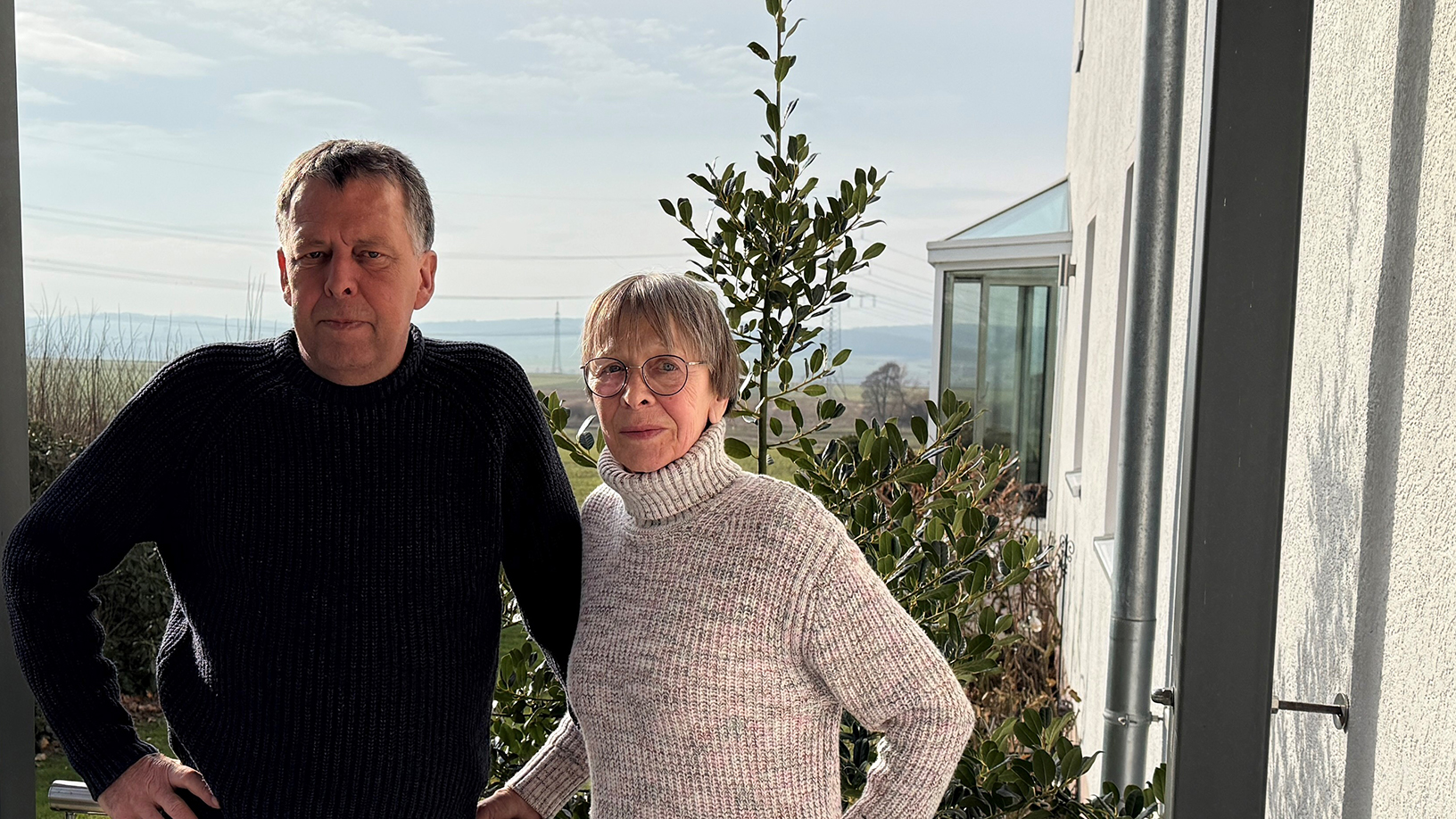 Ein Mann und eine Frau stehen nebneinander und lächeln in die Kamera