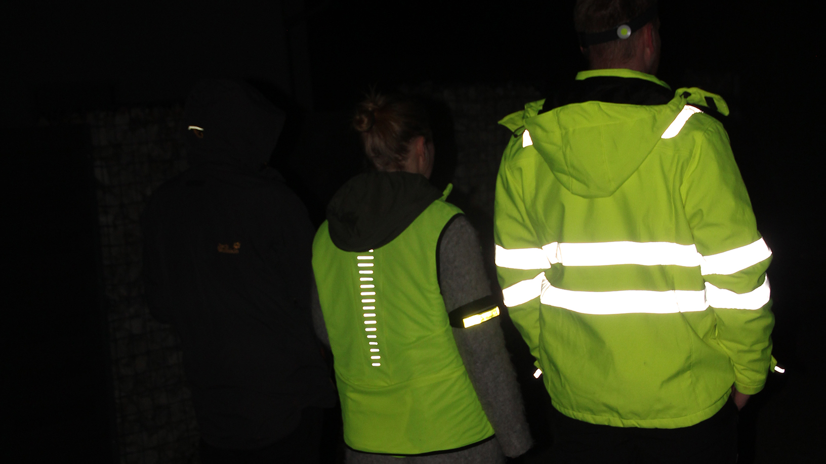 Personen mit und ohne Warnkleidung im Dunkeln