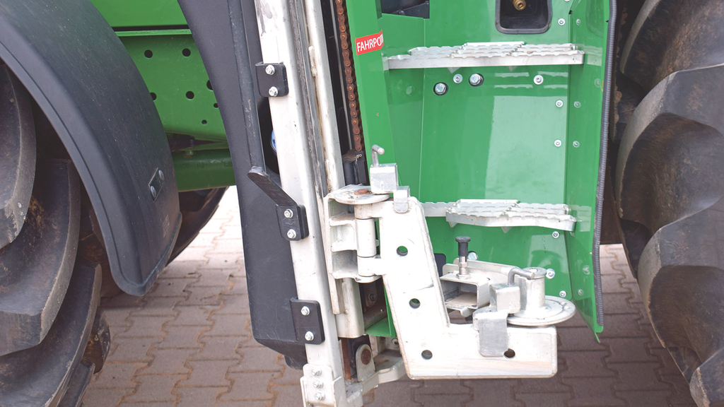 Vergrößerung des Bildes für Vor dem Trittbrett am Traktor wird die zusätzlich angebrachte Einstiegshilfe gezeigt. .