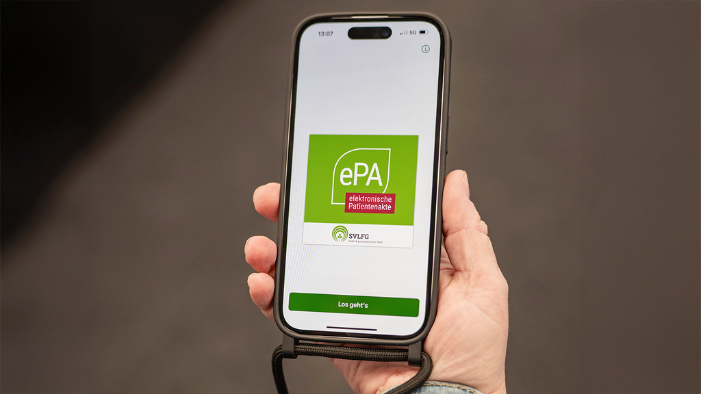 Vergrößerung des Bildes für Eine Hand hält ein Handy auf dem das Logo der ePa App zu sehen ist.