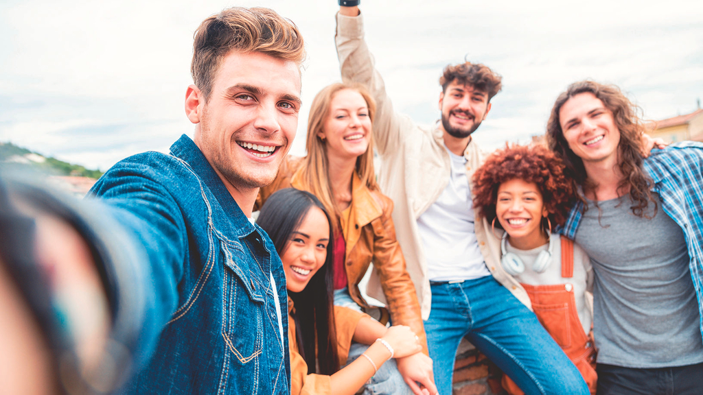 Vergrößerung des Bildes für Eine Gruppe vieler junger Menschen schaut in die Kamera..