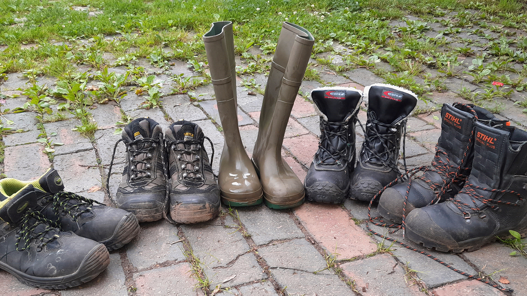 Vergrößerung des Bildes für Vier paar Sicherheitsschuhe stehen aufgereit.