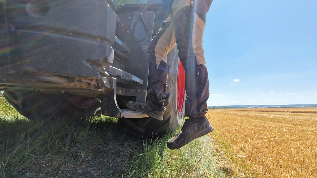 Vergrößerung des Bildes für Ein Mann steigt rückwärts vom Traktor ab.