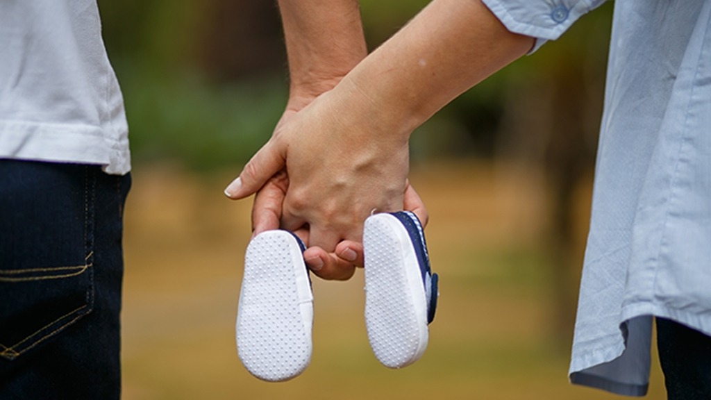 Vergrößerung des Bildes für Mann und Frau mit Babyschuhen.