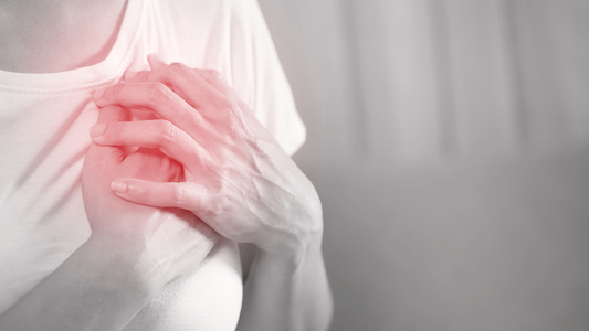 Zwei Hände einer Frau auf Herzhöhe